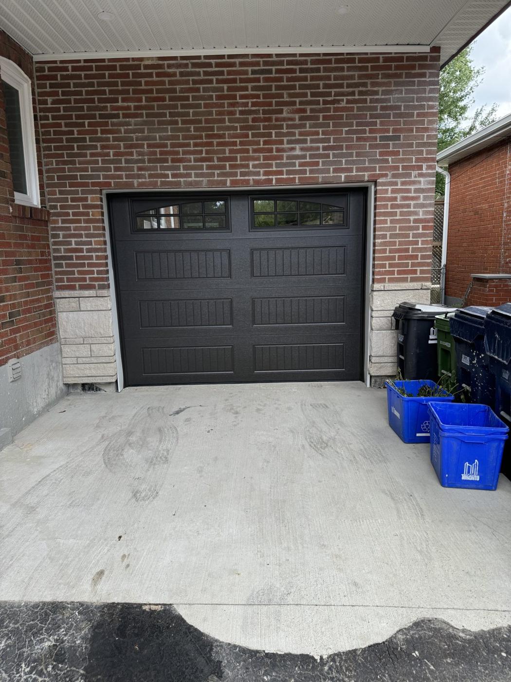 Finished brick detached garage with black insulated carriage-style garage door